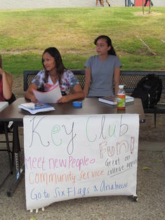 students sitting at a table with a sign for Key Club